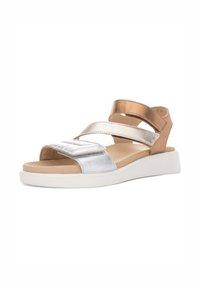 Metallisk sølv- og bronzefarvede sandaler med krydsende stropper, en polstret beige fodseng og en hvid gummisål. Åben tå-design og afslappet stil.