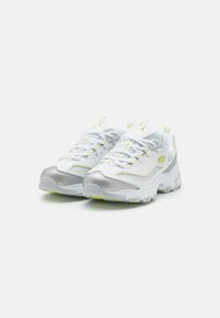 Weiße Sportschuhe mit silbernen Akzenten und gelben Highlights. Hergestellt aus einem Mesh- und Synthetikmaterial, mit einer dicken Sohle und strukturiertem Design.