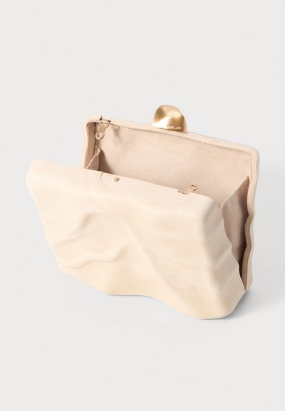 Pochette crème texturée avec un design ondulé, fermeture en métal doré et un intérieur ouvert révélant une doublure lisse.