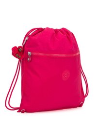 Bolsa de mano rosa con cordón, hecha de tela ligera, que presenta un bolsillo delantero con cremallera y un pequeño charm de oso de peluche adjunto a la cremallera.