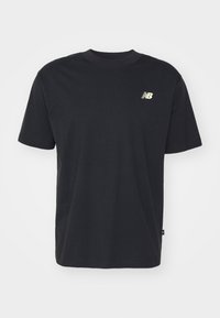 Camiseta de algodón negra con mangas cortas, cuello redondo y un pequeño logo dorado de New Balance en el pecho. Textura suave, corte casual.