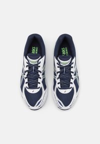 Marina mesh och syntetiska löparskor med vita accenter och grön logotyp. Har en lättviktsdesign, snörstängning och vadderade sula.