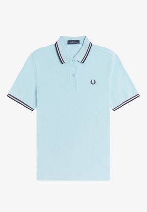 Polo bleu clair à manches courtes avec des rayures rouge foncé et bleu marine sur le col et les manches, patte de boutonnage à deux boutons, et petit logo couronne de laurier sur la poitrine.