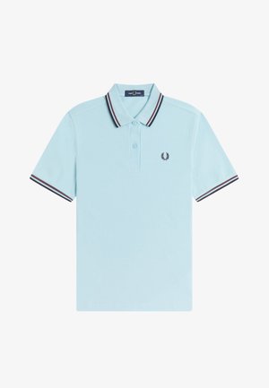 Polo bleu clair à manches courtes avec des rayures rouge foncé et bleu marine sur le col et les manches, patte de boutonnage à deux boutons, et petit logo couronne de laurier sur la poitrine.
