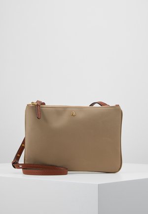 Beige rektangulær crossbody-taske med brun læderrem og lynlås, vist på en hvid piedestal mod en grå baggrund.