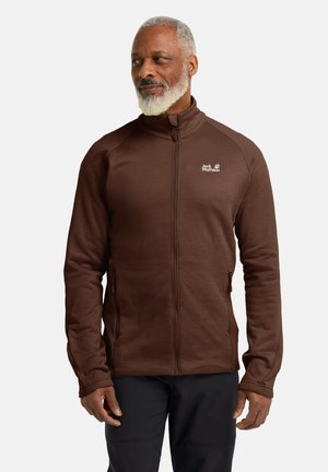Brown fleece jacket with a high collar, full zipper, and side pockets. Features logo on the chest and textured fabric for warmth.