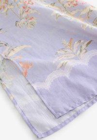 Lichtpaarse stof met bloemenprint in pasteltinten en geschulpte kantafwerking langs de rand, getoond gevouwen op een wit oppervlak.