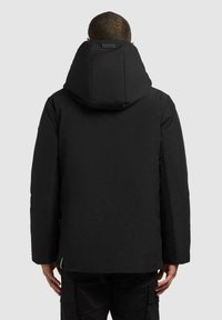 Sort polstret jakke med høj krave og oversized hætte. Har en glat tekstur og ingen synlige logoer eller hardware.