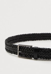 Cinturón de tela tejida negra, hecho de un material texturizado, que presenta una hebilla de metal con acabado mate y un acento de cuero cerca del cierre.