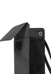 A sacchetto di stoffa nera con chiusura a pattina. Presenta un sistema di chiusura a strappo e un occhiello per il fissaggio. Texture liscia e design minimalista.