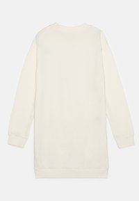 Ilga rankovė, ant kaklo priglundanti suknelė šviesiai kreminės spalvos, su nutrintais rankogaliais ir apvadu. Minkšta, lygi tekstūra be matomų raštų ar akcentų.