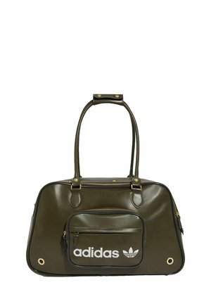 Sac polochon Adidas vert olive avec doubles poignées, poche zippée à l’avant, détails dorés et logo Adidas blanc avec trèfle sur la poche avant.