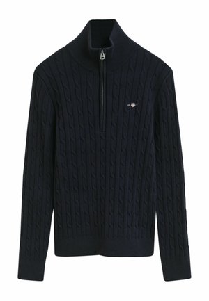 Marineblauwe gebreide trui met een gestructureerd kabelpatroon, hoge kraag en een halve rits. Bevat een klein logo op de linkerborst.