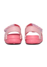 Rosa Sandalen mit gestreiftem Obermaterial, offenem Rückenausschnitt und verstellbarem Riemen. Strukturierte Gummisohle für besseren Halt, kontrastierende Innenpolsterung.