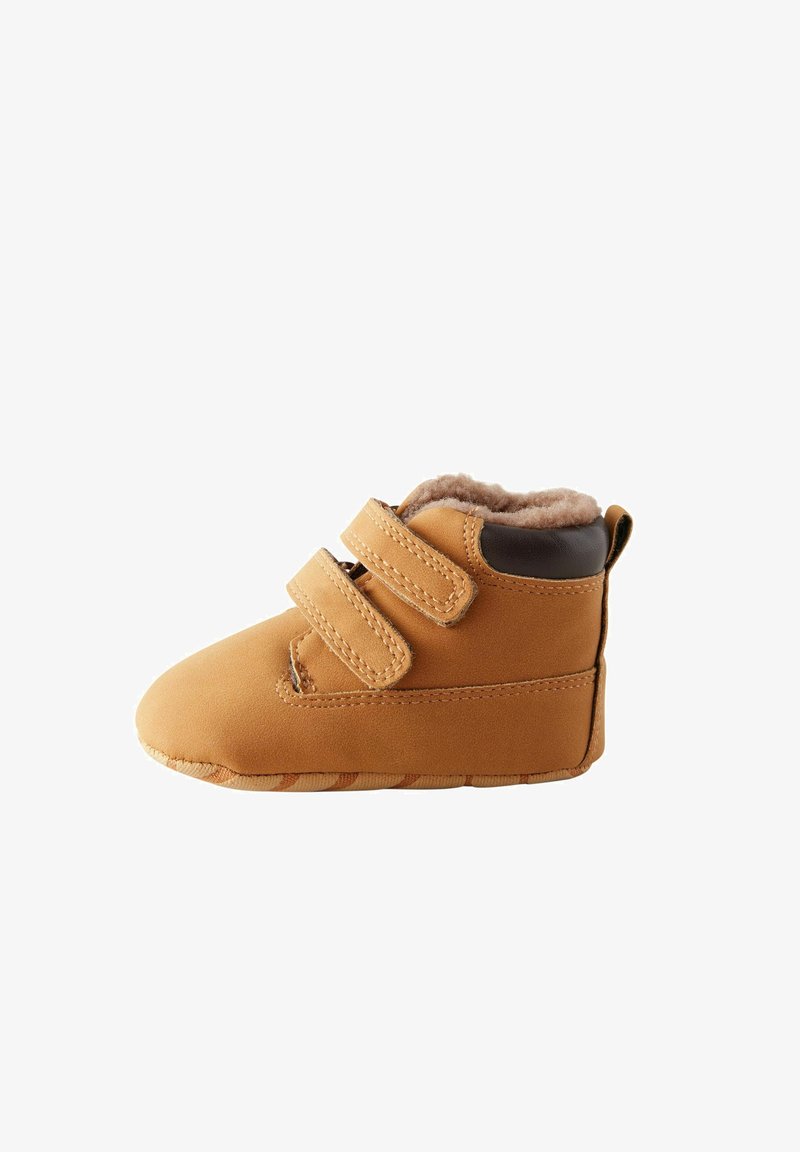 Petite botte beige pour bébé avec double fermeture à scratch, doublure douce et col de talon rembourré marron foncé, vue de côté sur fond blanc.