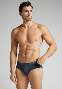 Mörkgrå herrkalsonger med en slät textur, formad passform och mjukt midjeband med en diskret varumärkesnamn. Minimalistisk design utan mönster.