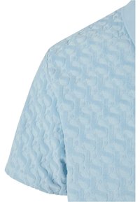 Polo bleu clair avec une surface texturée présentant un motif répétitif. Manches courtes et col classique.