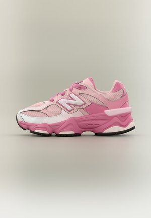 Ροζ και άσπρο αθλητικό παπούτσι New Balance με επάνω μέρος από δίχτυ και δέρμα, παχιά σόλα και λογότυπο «N» στο πλάι, εμφανιζόμενο από την εξωτερική πλευρά.