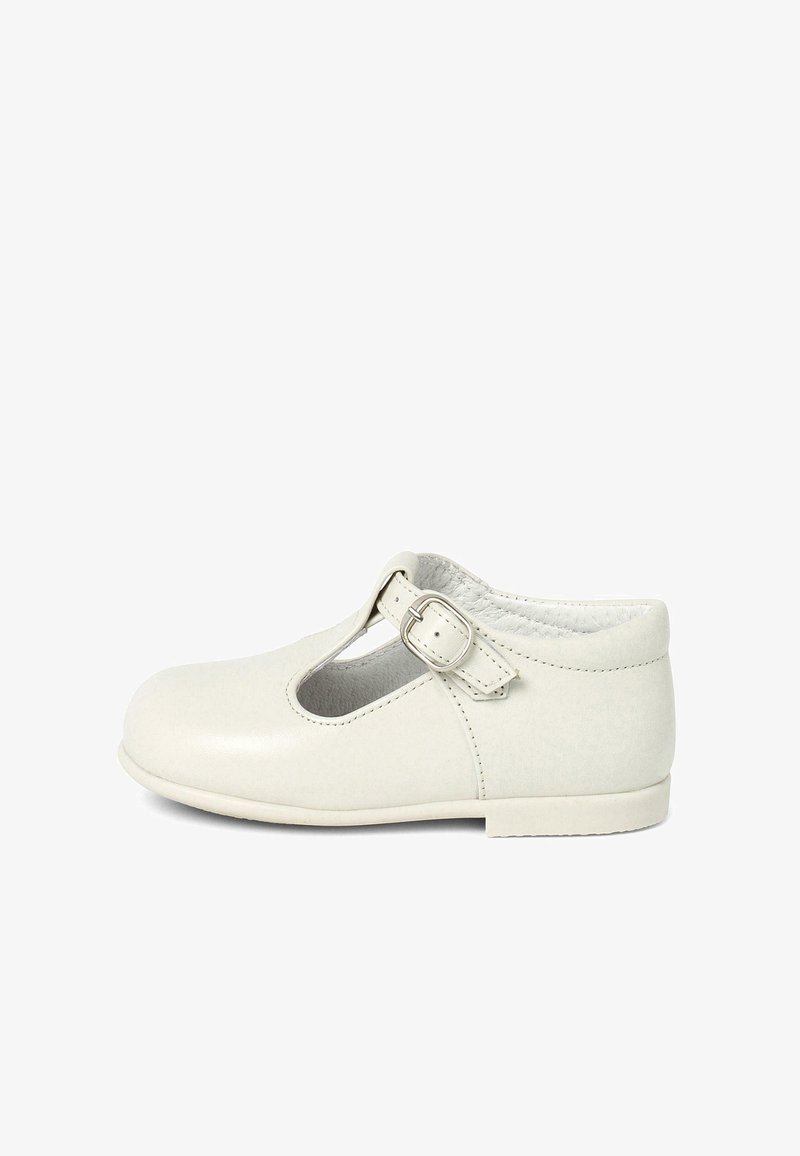 Zapato Mary Jane de piel blanca con puntera redonda, tira en T y detalle de hebilla, textura suave y suela plana.