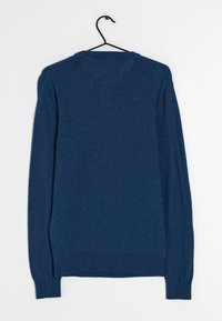 Dunkelblaues Langarm-Sweatshirt aus strukturiertem Strick, mit Rundhalsausschnitt und gerippten Bündchen, hängt an einem schwarzen Haken.