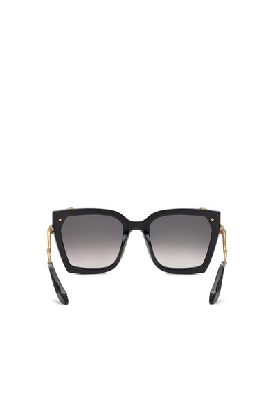 Lunettes de soleil carrées noires oversize avec verres gris dégradés et branches dorées texturées, montrées de face sur fond blanc.