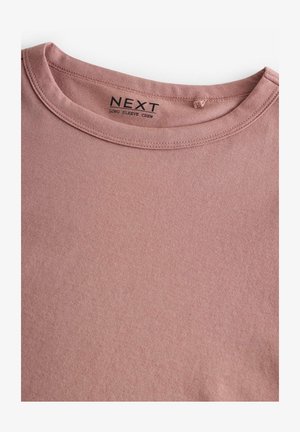 Pika pikkade varrukatega klassikaline kaelusega särk pehmest roosast kangast, mis sisaldab sujuvat kraed ja "NEXT" brändingu sildikest. Sujuv tekstuur, mustriteta.