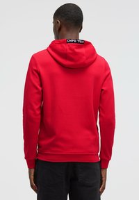 Red hoodie with a classic cut, featuring a soft texture, a drawstring hood, and a black "CMPD TEAM" label at the back neckline.