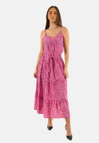 Robe maxi à imprimé léopard rose avec un corsage ajusté, des bretelles spaghetti et une taille à nouer ; présente une jupe à volants superposés et un tissu léger.