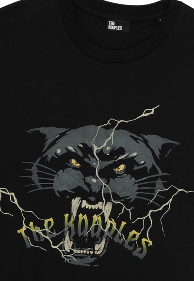 Svart bomulls t-skjorte med grafikk av en brølende panter med gule øyne, omringet av lyn, og teksten "the kooples" i gull.