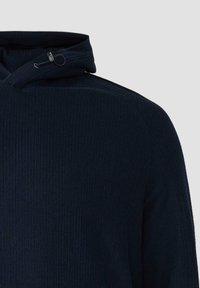 Marineblauwe geribbelde hoodie met een hoge kraag met verstelbare koordjes en een gestructureerde stof, met een aansluitend ontwerp en strakke lijnen.