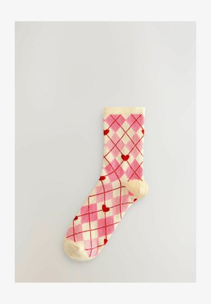 Roza in smetana nogavica z diamanti in rdečimi srci, rebrastim robom in ojačenim prstom. Mehak material z gladko teksturo.