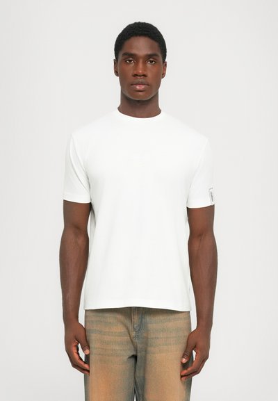 Witte katoenen t-shirt met een ronde hals en korte mouwen, voorzien van een subtiele logo op de borst en een label op de linker mouw.