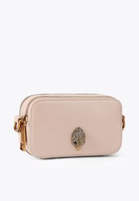 Sac en cuir beige de forme rectangulaire, doté d'accessoires dorés et d'une décoration en forme de feuille à l'avant. Comprend une double fermeture éclair.
