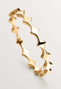 Pulsera de oro con un diseño de ola que presenta secciones alternadas cóncavas y convexas; superficie suave y acabado brillante.