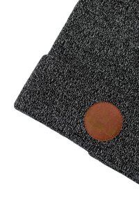 Czarna dzianinowa czapka typu beanie z teksturowanej tkaniny, z okrągłą brązową skórzaną naszywką z wzorem, umieszczoną na dolnej części przodu.