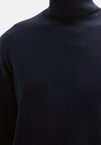 Granatowy sweter z wysokim kołnierzem wykonany z miękkiej, gładkiej przędzy. Dopasowany krój z prążkowanym kołnierzem, bez widocznych wzorów czy zdobień.