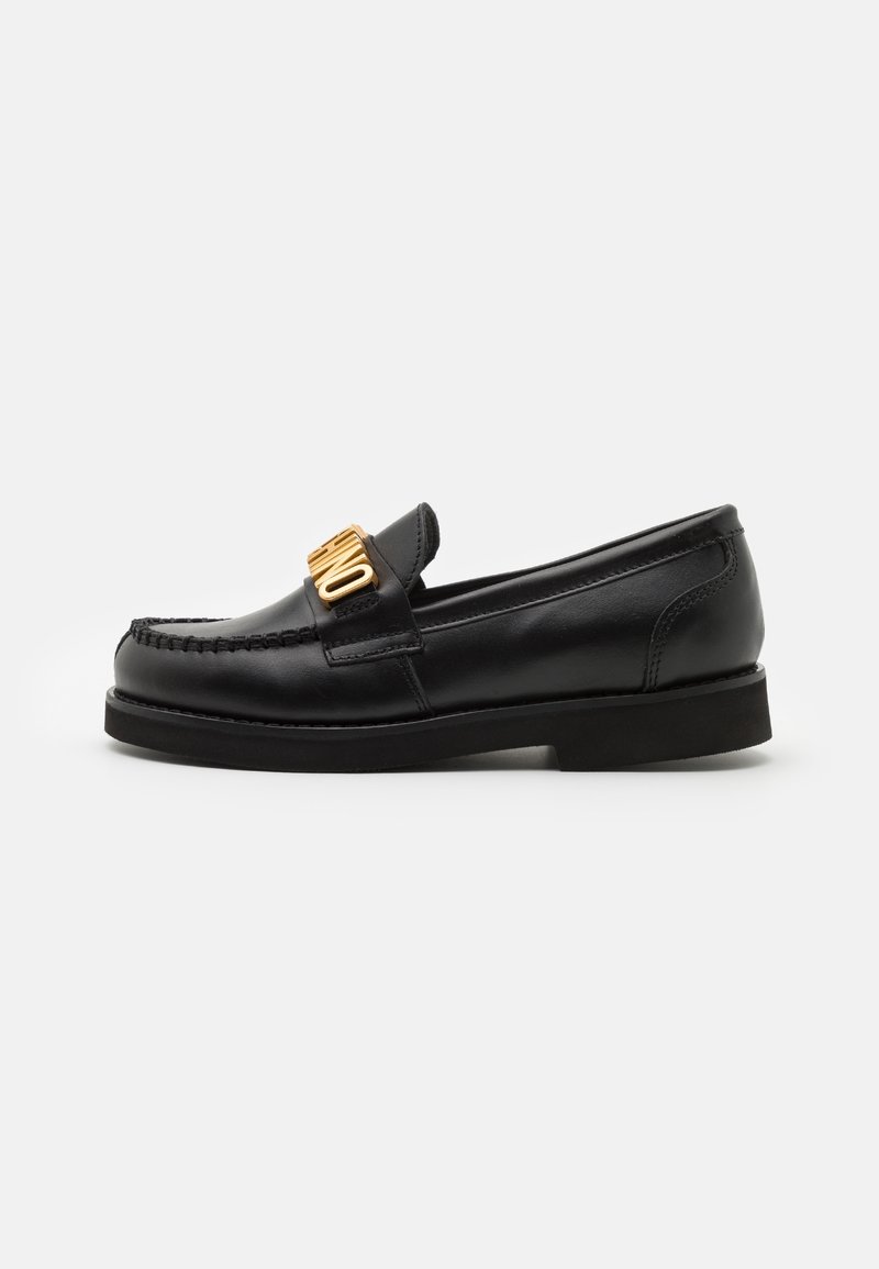 Mocassin en cuir noir avec semelle épaisse et détail métallique doré prononcé sur la tige, avec un design moc toe cousu.