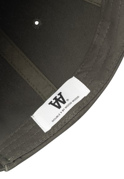 Casquette vert foncé en tissu texturé, avec une étiquette intérieure portant l'inscription "DOUBLE V BY WOOD WOOD" et un trou de ventilation circulaire.