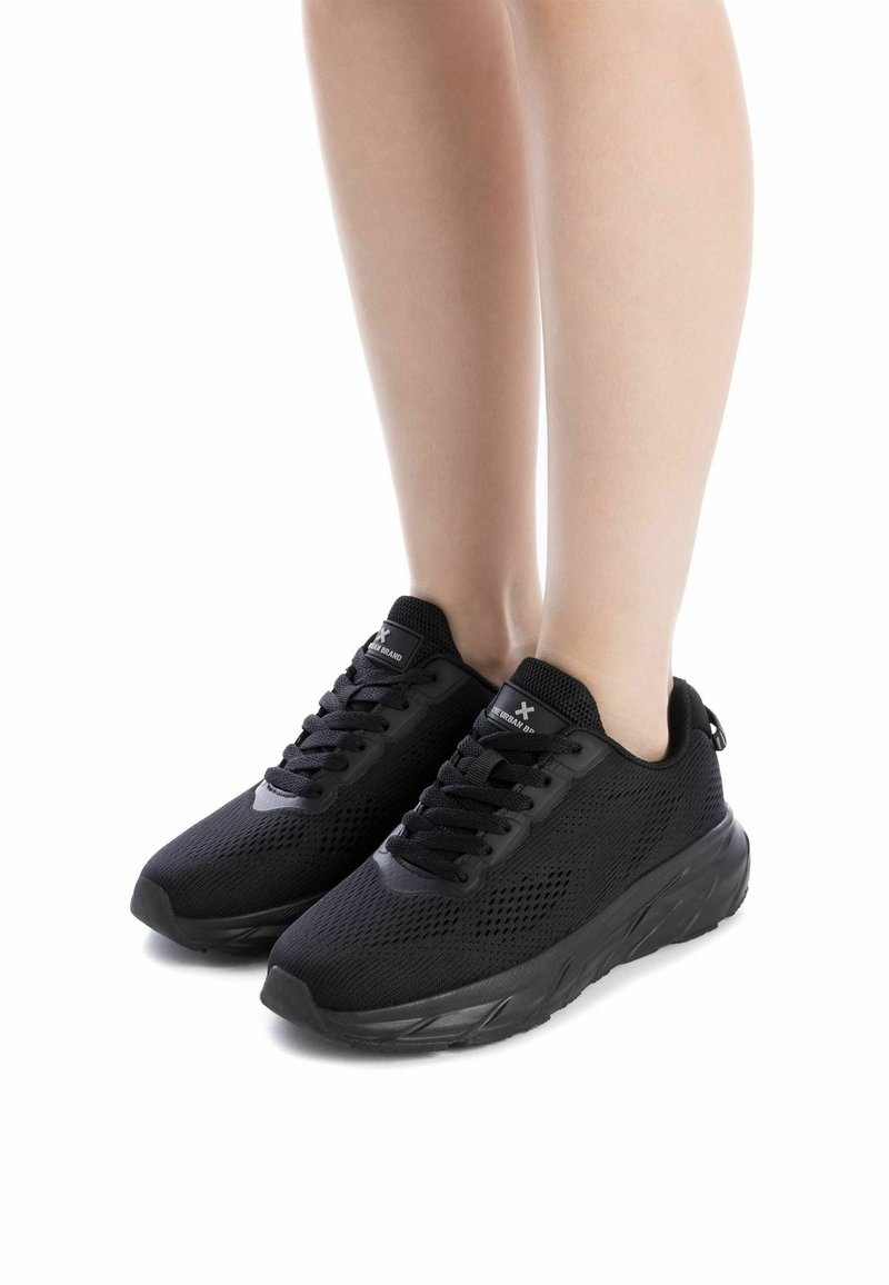 Zapatillas deportivas negras con parte superior de malla, diseño con cordones, cuello acolchado y suela texturizada, que cuentan con una construcción ligera.