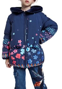 Námořnická pufovaná bunda s květinovým potiskem v růžové a modré barvě. Má kapuci, přední zip a pruhovaný lem. Měkká prošívaná textura.
