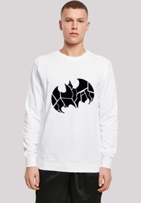 Hvid sweatshirt med et sort, revnet flagermus-symbolgrafik i midten. Materialet ser blødt ud, med lange ærmer og rund halsudskæring.