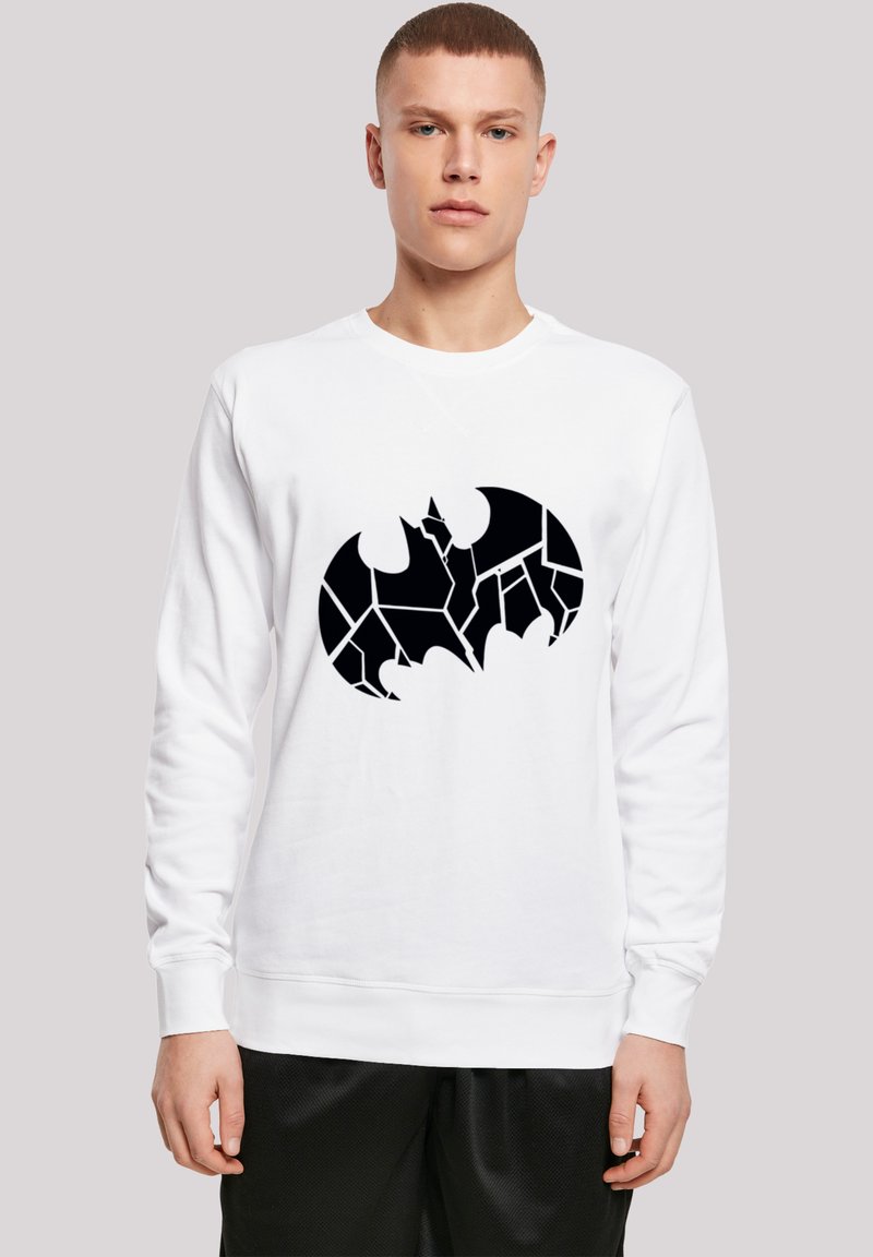 Hvid sweatshirt med et sort, revnet flagermus-symbolgrafik i midten. Materialet ser blødt ud, med lange ærmer og rund halsudskæring.