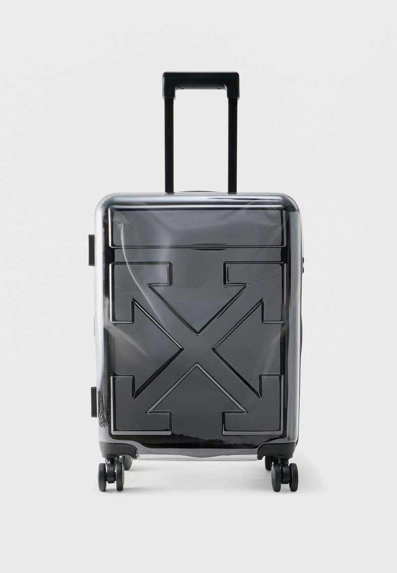 Μαύρη σκληρή βαλίτσα με επεκτεινόμενο χειρολαβή και τέσσερις ρόδες, με ανάγλυφο σχέδιο σταυρωτών βελών στο μπροστινό μέρος.