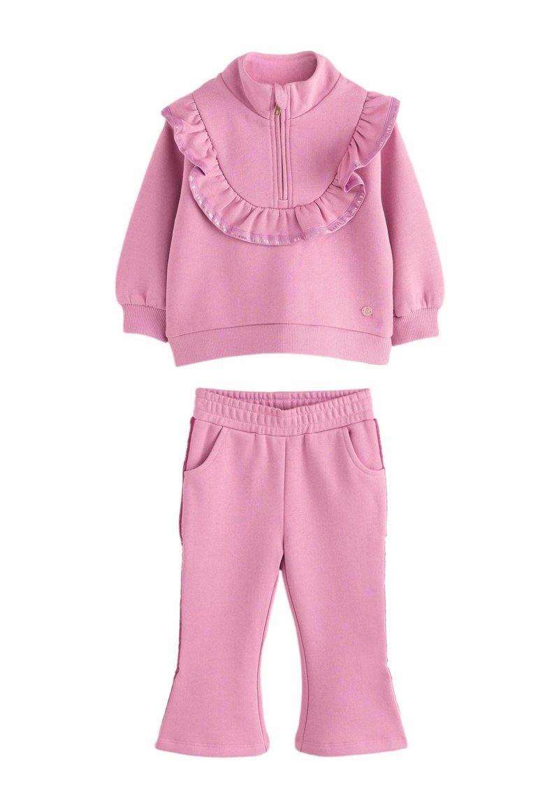 Chándal de forro polar rosa que incluye una sudadera con cremallera con detalles de volantes y unos pantalones ajustados a juego con cintura elástica y bolsillos.