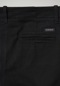 Zwarte katoen broek met een achterzak met een horizontale opening en een geborduurd logo label. Soepele textuur met een standaard tailleband.