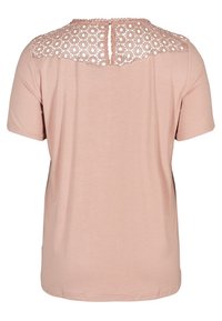 Chemise rose clair à manches courtes avec un détail en dentelle crochetée sur le haut du dos et une petite ouverture en forme de goutte à l'encolure.