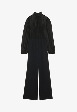 Combinaison noire avec un col montant et de longues manches bouffantes. Section supérieure transparente avec des détails froncés ; design à jambes larges en tissu mat.