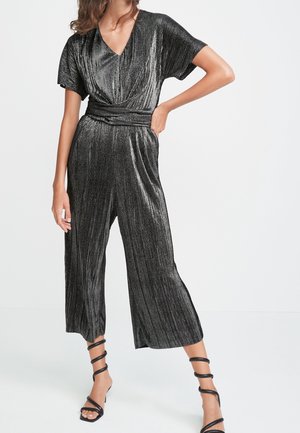 Jumpsuit noir métallique avec un décolleté en V, des manches courtes, une taille cintrée et des jambes larges et raccourcies dotées de plis verticaux et de poches.