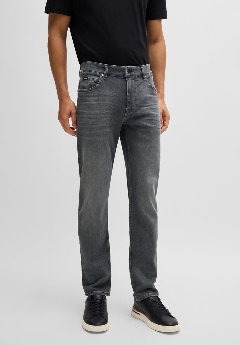 Vaqueros de denim gris con un corte recto, que cuentan con un cierre frontal de cremallera y botón, un ligero desvanecimiento y un estilo clásico de cinco bolsillos.