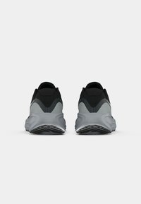 Scarpe sportive nere e grigie con una tomaia testurizzata e suola ammortizzata, dotate di una suola in gomma per la trazione e un design minimalista.